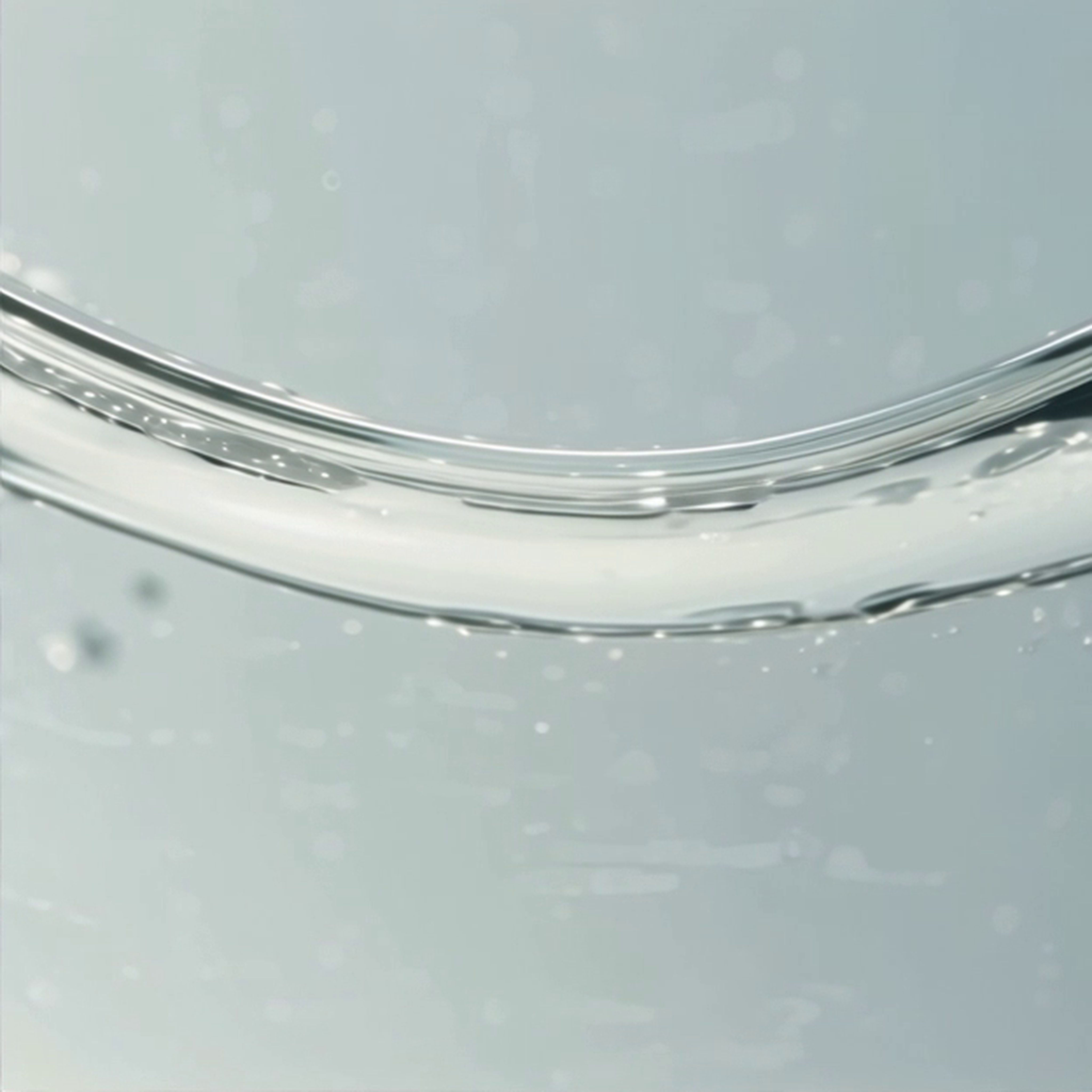 Glossy curved surface of transparent liquid with scattered bubbles