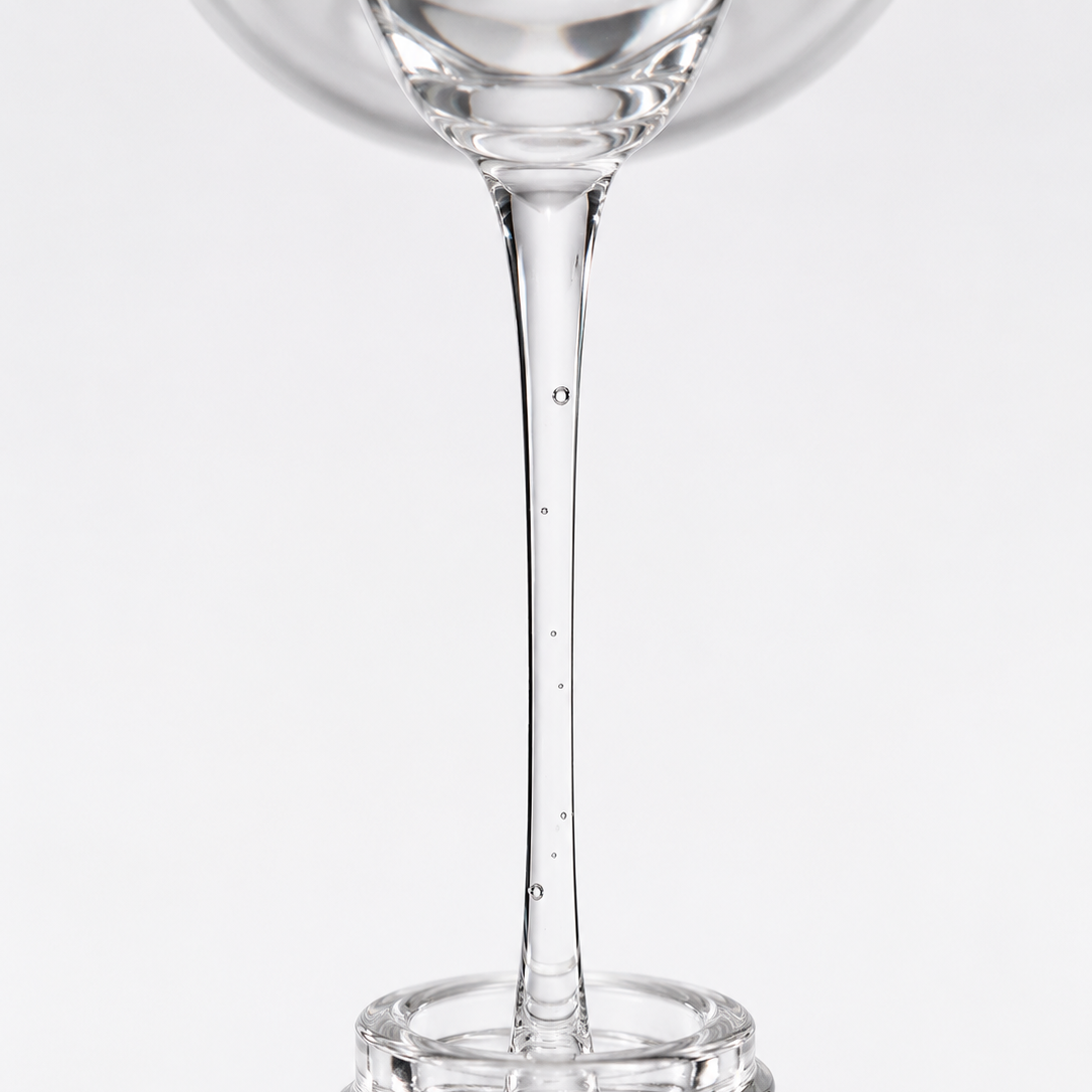 Close-up of clear ampoule serum flowing smoothly to highlight its lightweight, transparent texture.