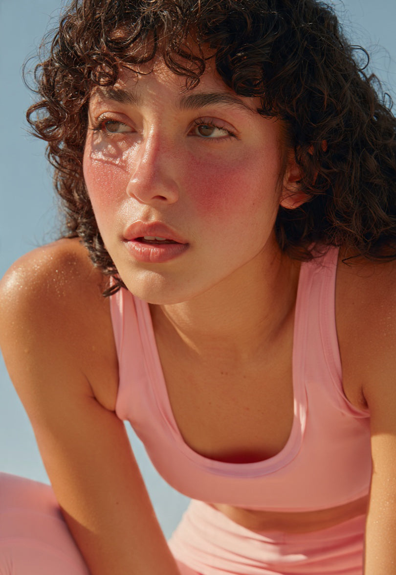 Close-up of a woman with flushed cheeks after sun exposure in pink activewear