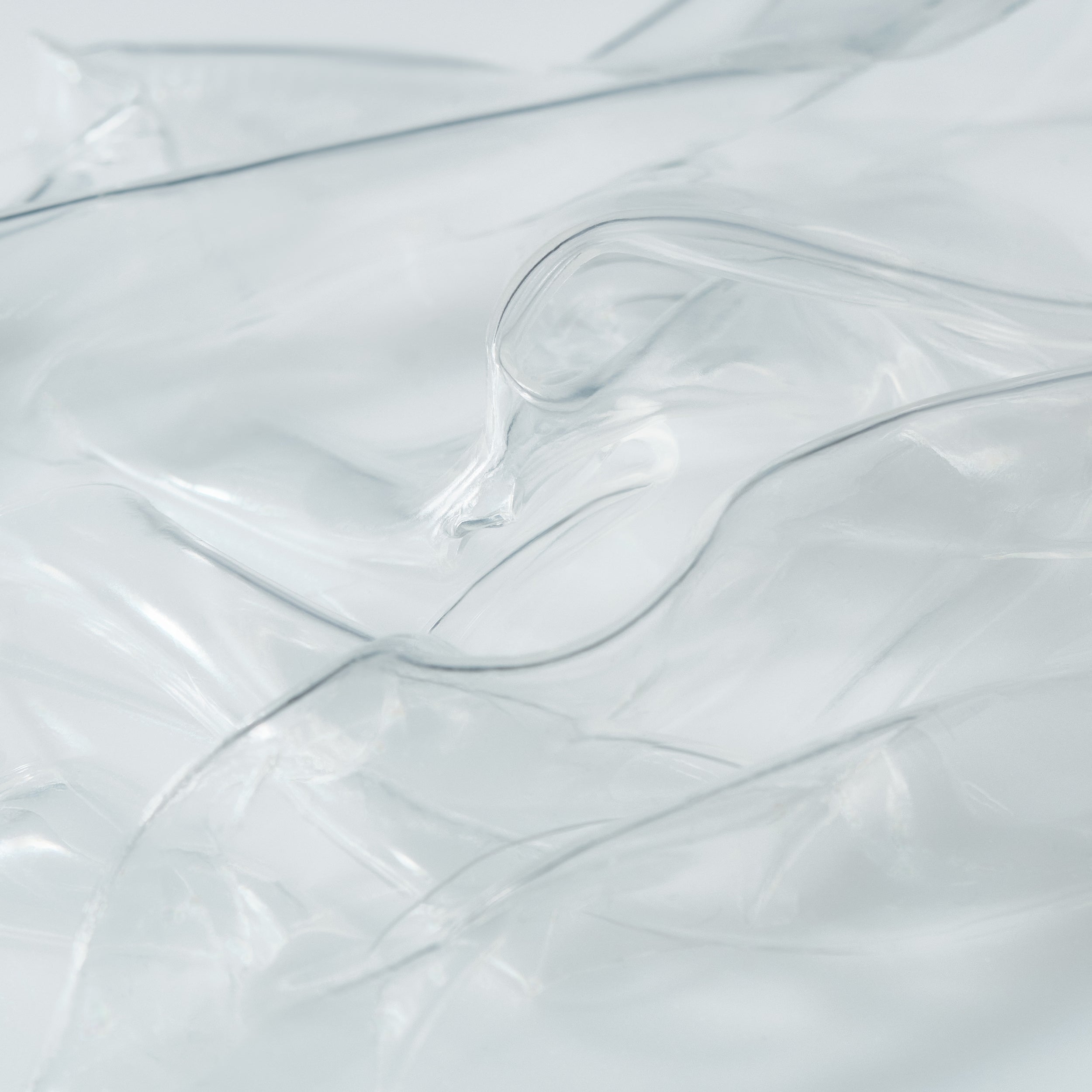 Close-up of transparent hydrogel mask sheets layered to highlight their smooth, ultra-thin texture.