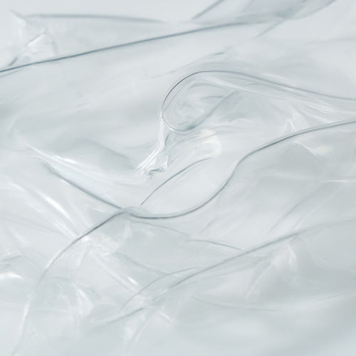 Close-up of transparent hydrogel mask sheets layered to highlight their smooth, ultra-thin texture.