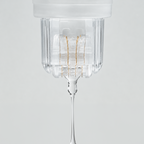 Close-up of the Roller Gold device dispensing a clear serum through its gold-plated micro-needle roller head.