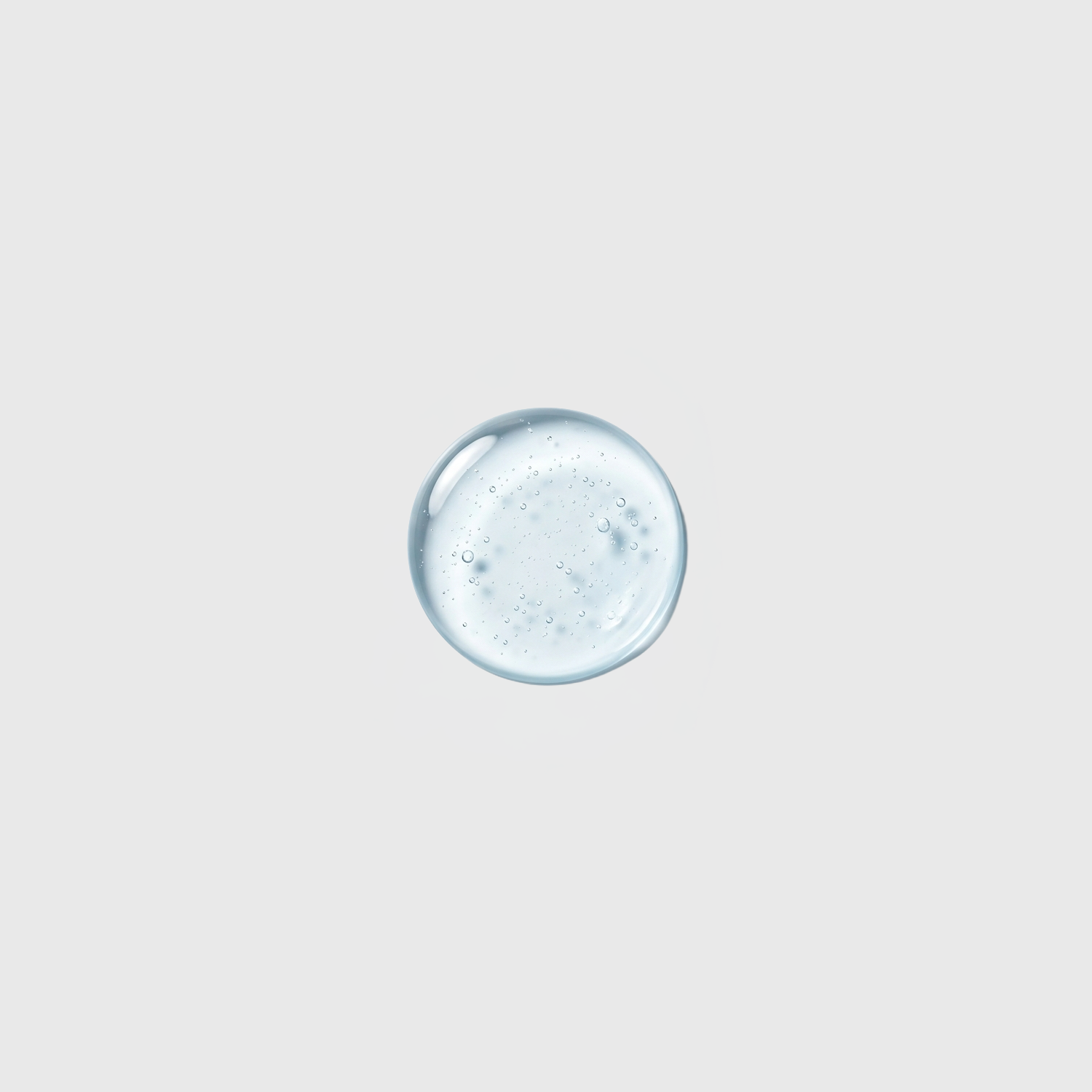 Light blue gel droplet with tiny air bubbles on a light gray background